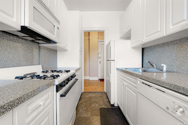 kitchen featuring decorative backsplash, white cabinetry, white appliances, and sink