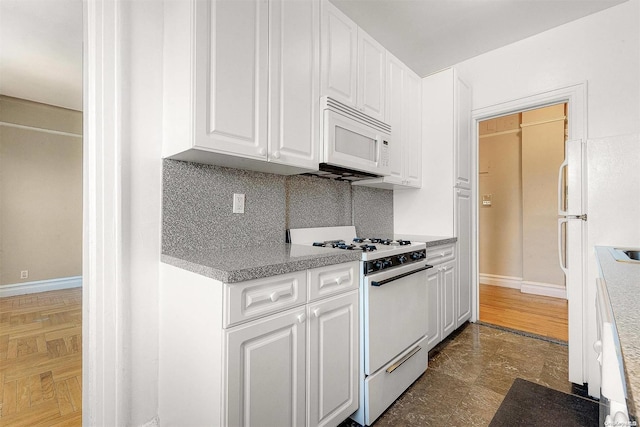 kitchen featuring decorative backsplash, white cabinets, and white appliances