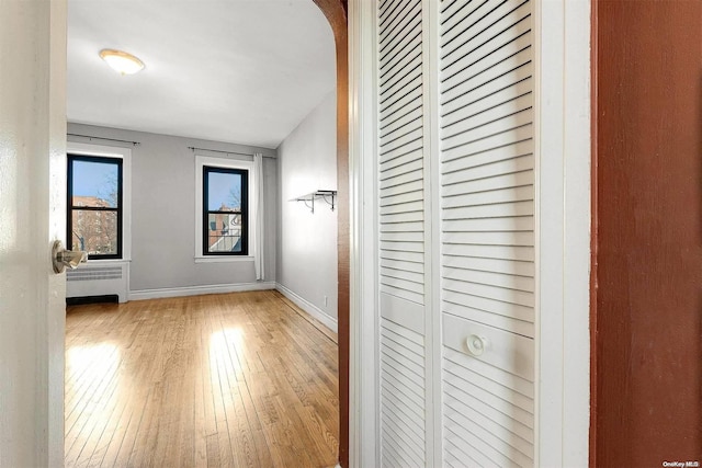 hallway featuring radiator and light hardwood / wood-style flooring