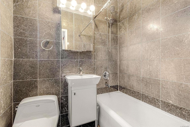 full bathroom with toilet, vanity, tiled shower / bath combo, and tile walls