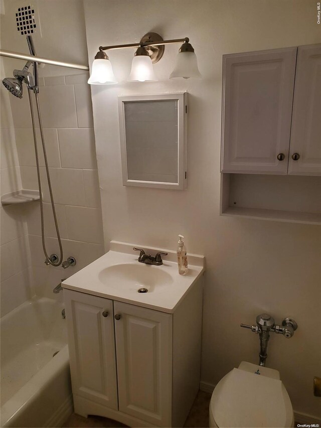 full bathroom featuring vanity, tiled shower / bath combo, and toilet