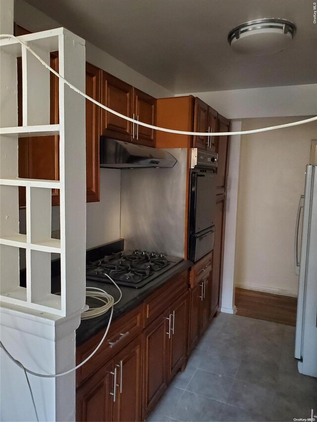 kitchen with gas stovetop, oven, and white refrigerator