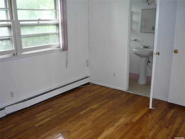 1449 Grand Ave, North Baldwin, NY 11510 - unfurnished bedroom with multiple windows, electric panel, dark hardwood / wood-style floors, and a baseboard heating unit
