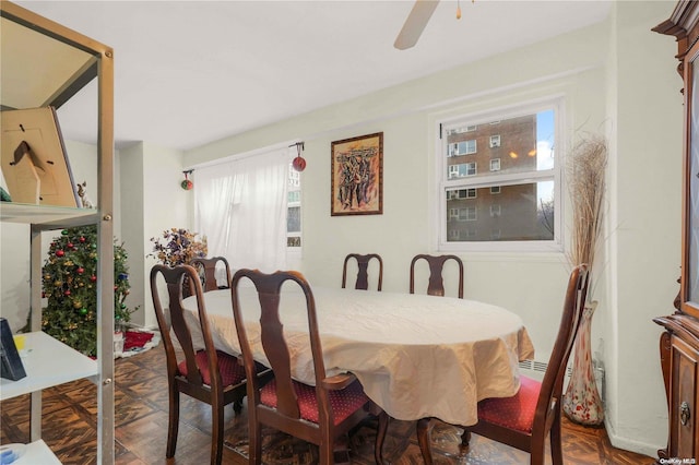 dining area featuring ceiling fan, a healthy amount of sunlight, and parquet flooring