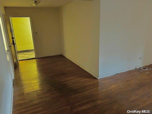 unfurnished room featuring dark hardwood / wood-style flooring