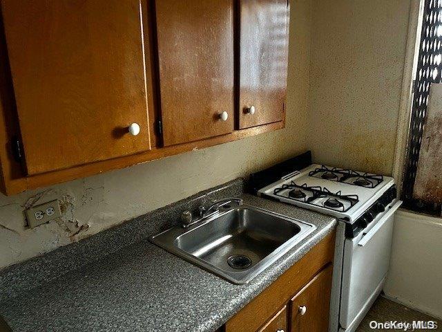 kitchen featuring white gas range and sink