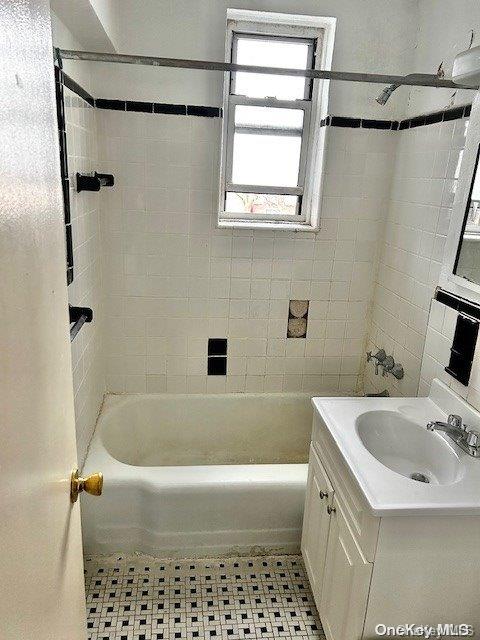 bathroom featuring tile patterned floors, vanity, and tiled shower / bath