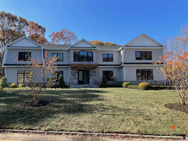 view of front of property featuring stone siding and a front yard