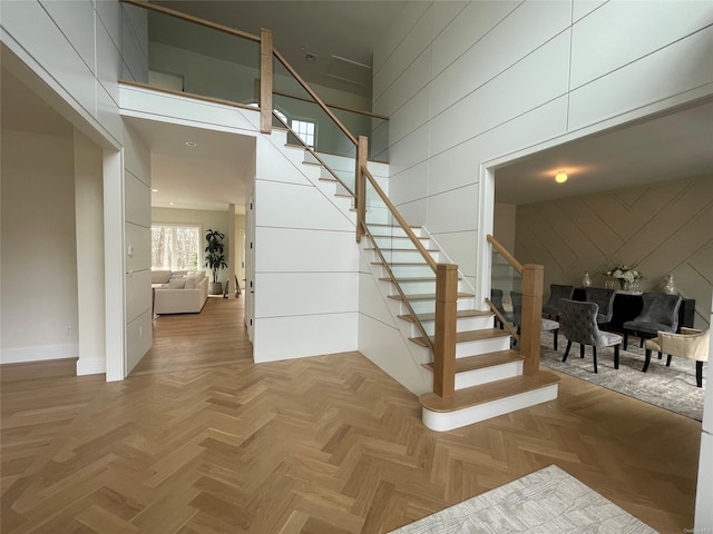 staircase featuring a towering ceiling