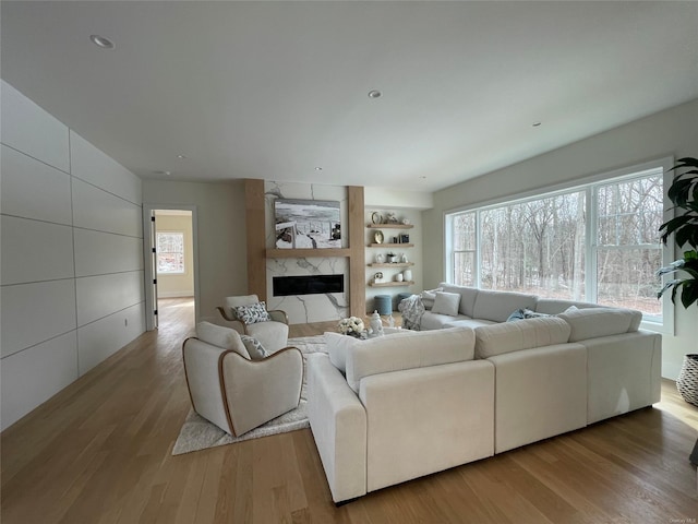 living room with a healthy amount of sunlight, light wood finished floors, and a fireplace