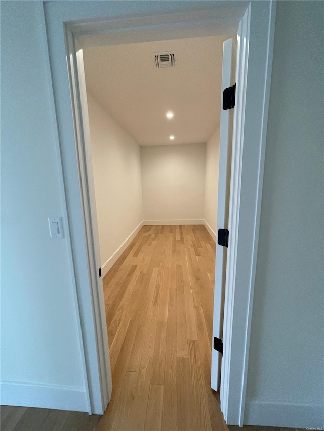 hallway featuring light wood-style flooring, visible vents, baseboards, and recessed lighting