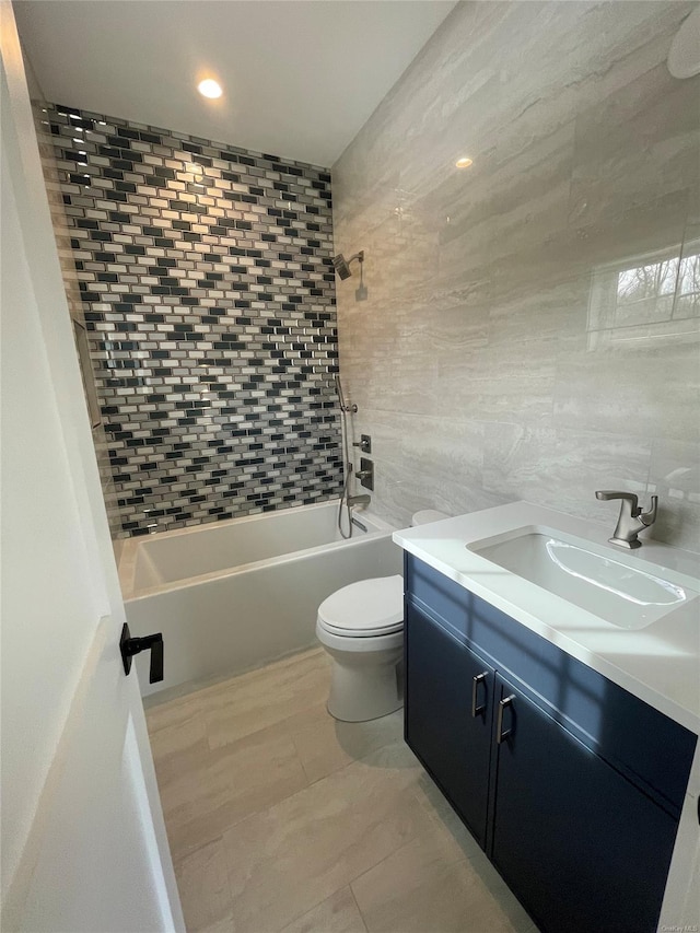 full bath featuring toilet, vanity, tile walls, and shower / bathtub combination