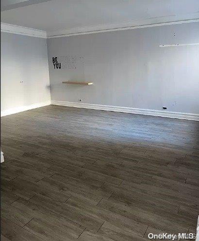 empty room featuring dark hardwood / wood-style flooring and ornamental molding