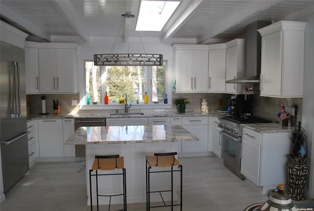 kitchen featuring wall chimney exhaust hood, sink, white cabinetry, and stainless steel appliances