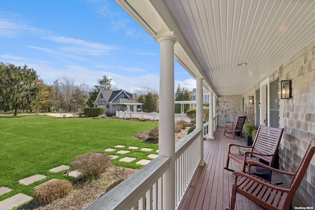 deck featuring covered porch and a lawn