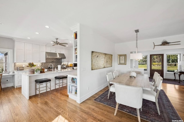 dining area with light wood-type flooring and sink