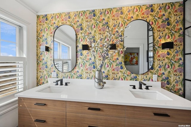 bathroom featuring ornamental molding, vanity, and a healthy amount of sunlight