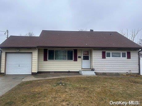 single story home featuring a front yard and a garage