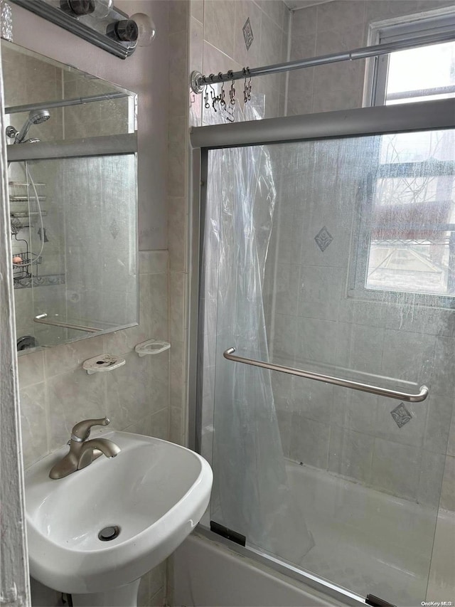 bathroom with enclosed tub / shower combo and sink