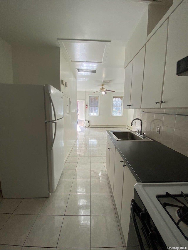 kitchen featuring white cabinets, light tile patterned flooring, white appliances, and sink