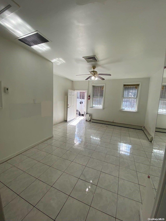 tiled spare room featuring ceiling fan