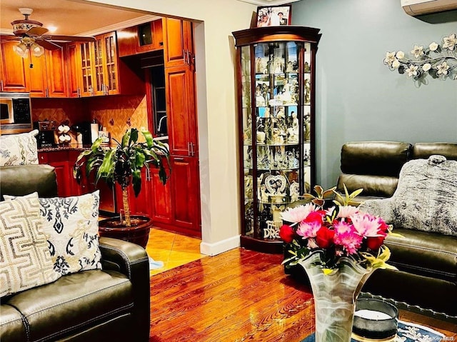 living room featuring an AC wall unit, ceiling fan, and light hardwood / wood-style flooring