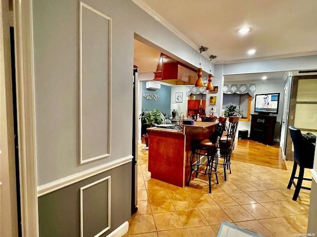 kitchen featuring a kitchen bar, crown molding, light tile patterned flooring, and a wall mounted air conditioner