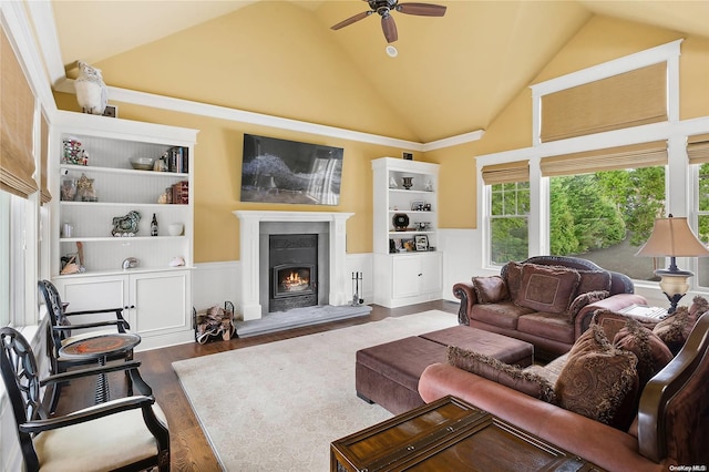 living room featuring ceiling fan, dark hardwood / wood-style flooring, high vaulted ceiling, and built in shelves