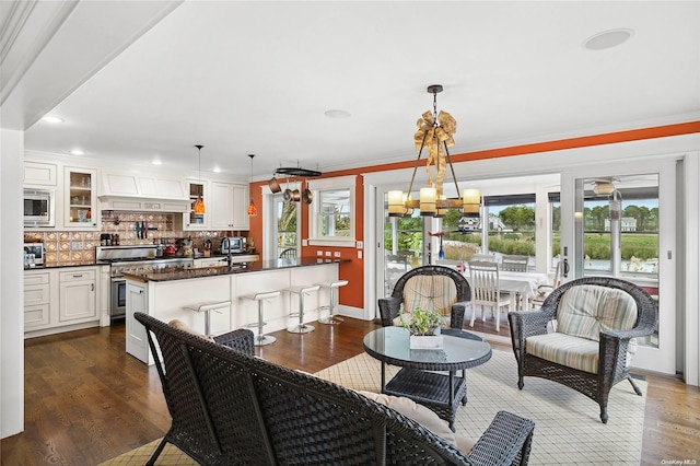 interior space featuring pendant lighting, white cabinetry, stainless steel appliances, and a wealth of natural light