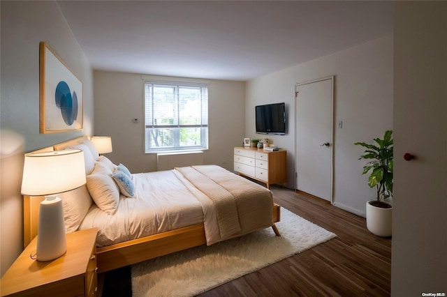 bedroom with dark hardwood / wood-style flooring