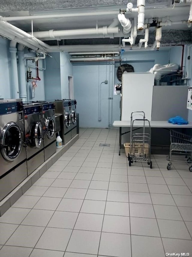 basement featuring washing machine and dryer, stacked washer / drying machine, and light tile patterned flooring