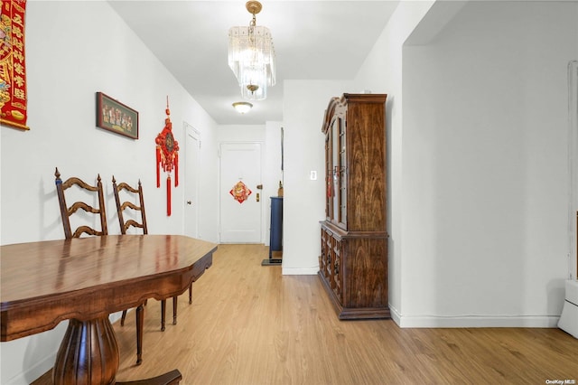 dining space featuring light hardwood / wood-style floors and a chandelier