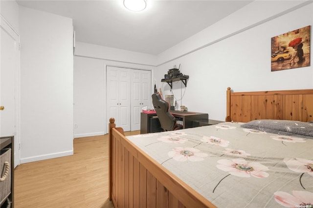 bedroom with light hardwood / wood-style floors and a closet