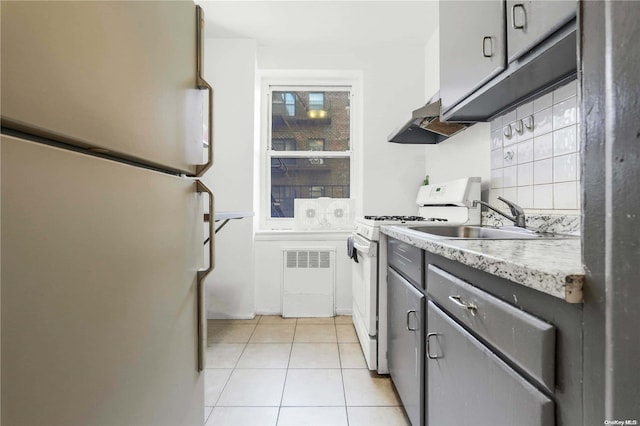 kitchen with white appliances, sink, decorative backsplash, light tile patterned floors, and extractor fan