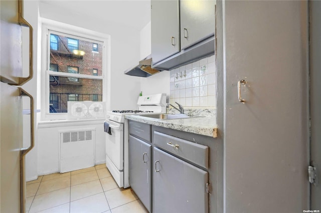 kitchen with tasteful backsplash, white appliances, ventilation hood, light tile patterned floors, and gray cabinets