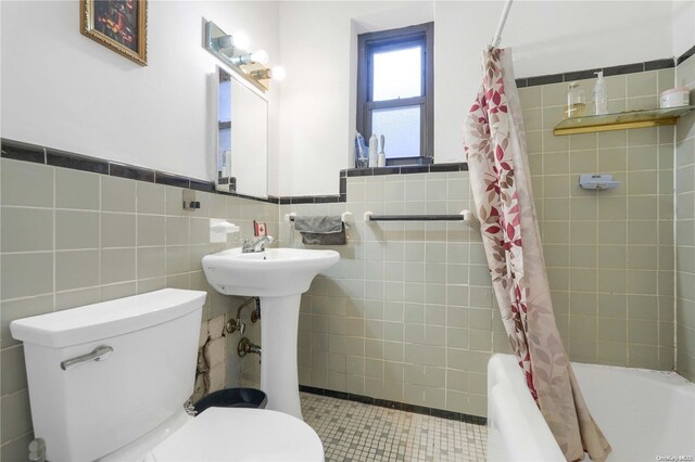 full bathroom with shower / bath combo with shower curtain, tile patterned flooring, tile walls, and toilet