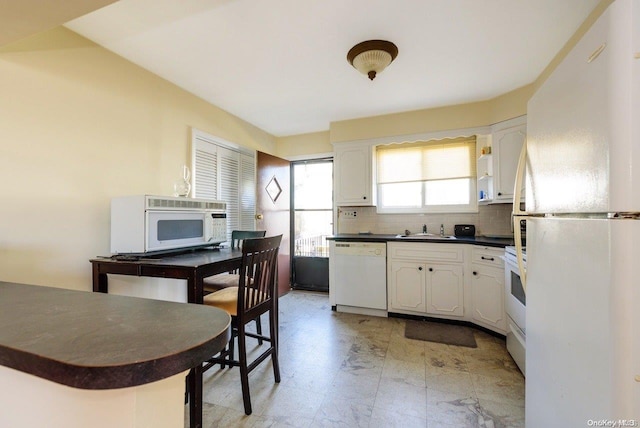 kitchen with decorative backsplash, white cabinetry, white appliances, and sink