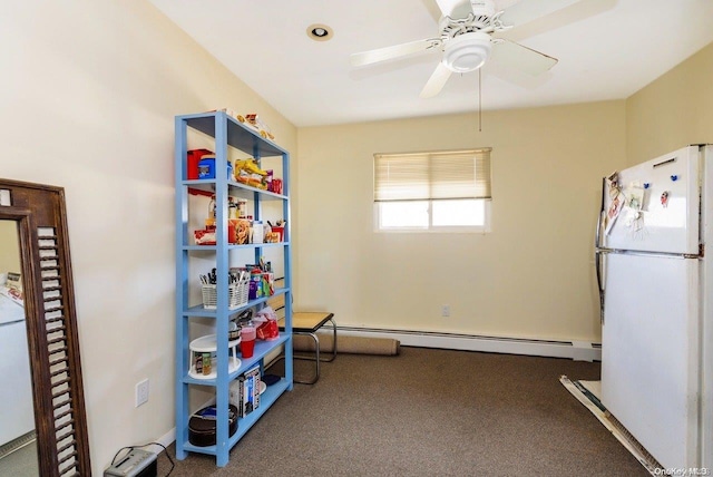 recreation room with baseboard heating, ceiling fan, and dark colored carpet