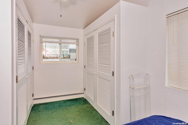 hall featuring dark colored carpet and baseboard heating