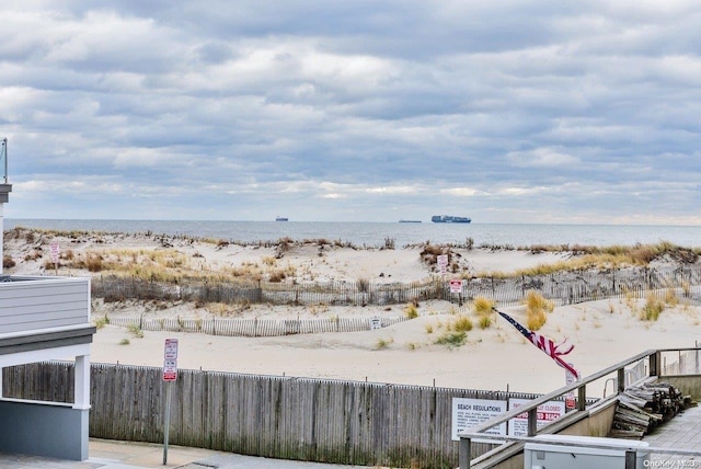 view of yard featuring a water view and a beach view