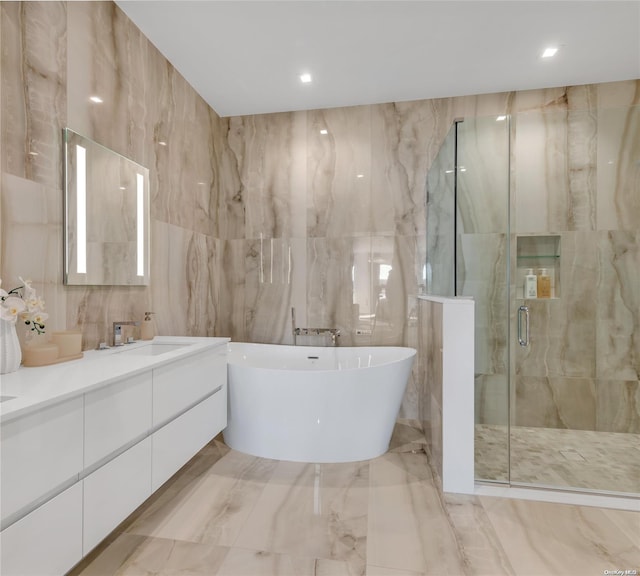 bathroom featuring vanity, separate shower and tub, and tile walls