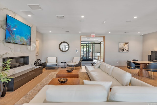 living room with light wood-type flooring and a fireplace