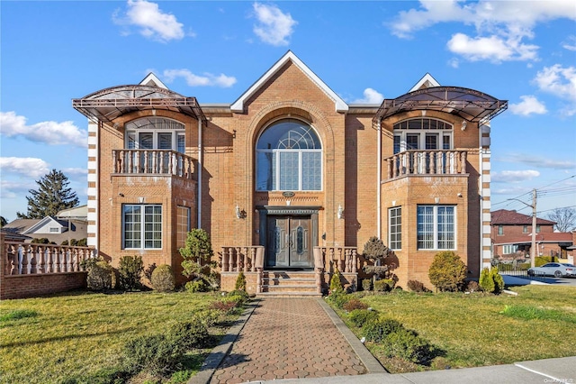 view of front of house featuring a balcony and a front lawn