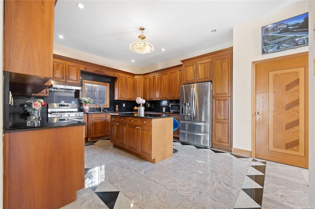 kitchen featuring sink, hanging light fixtures, stainless steel appliances, decorative backsplash, and a kitchen island