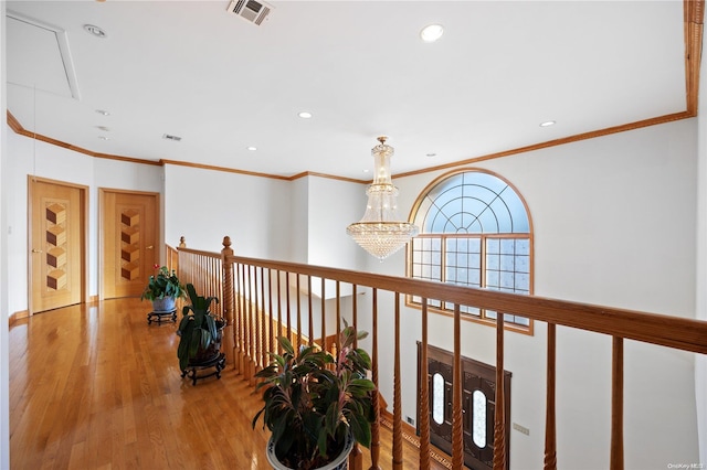 hallway featuring crown molding, a chandelier, and light wood-type flooring