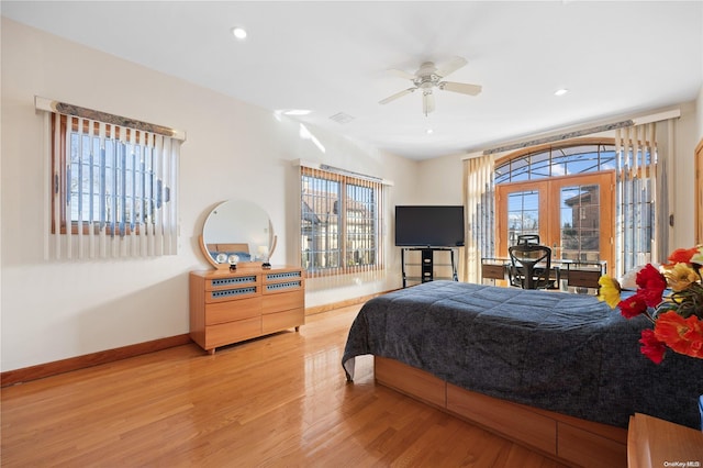 bedroom with hardwood / wood-style floors, french doors, multiple windows, and ceiling fan