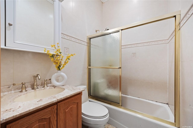 full bathroom featuring decorative backsplash, bath / shower combo with glass door, vanity, tile walls, and toilet