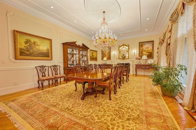 dining space featuring light hardwood / wood-style floors, ornamental molding, and an inviting chandelier