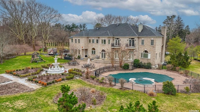 back of property featuring a patio area, a yard, and a covered pool