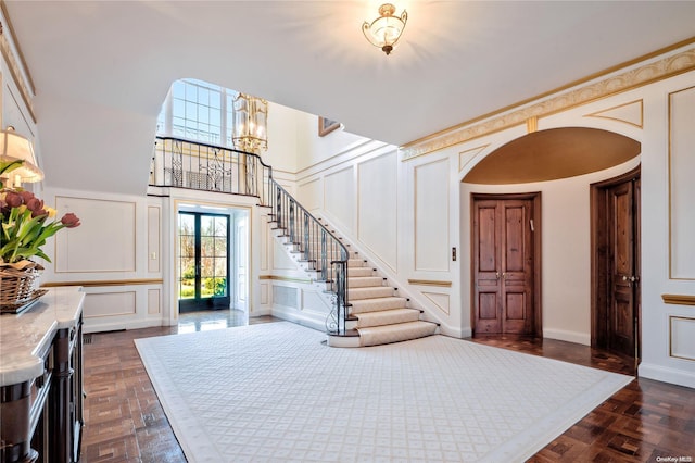 foyer with french doors, dark wood-type flooring, and a notable chandelier